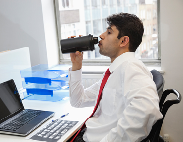 Man Drinking At Desk